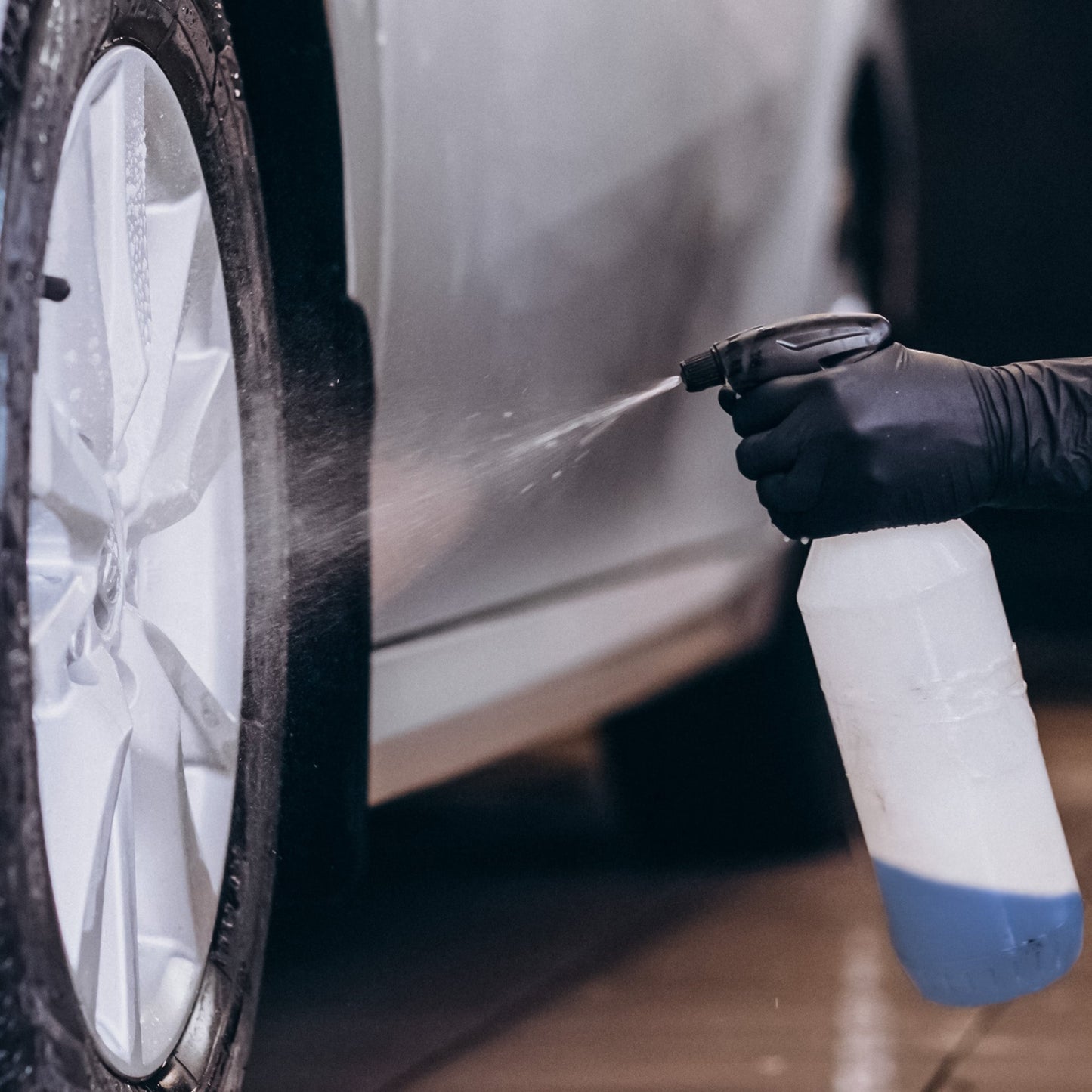 Applying Blue Beast Degreaser and Multi-Purpose Cleaner on car tire with spray bottle.